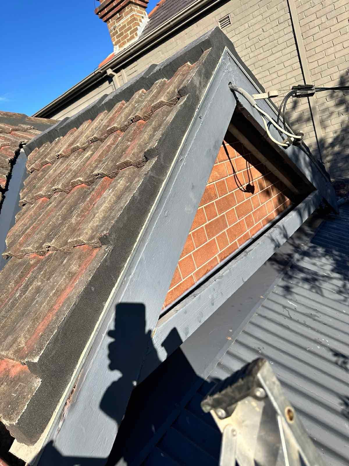 Roof flashing repair near chimney and brick wall